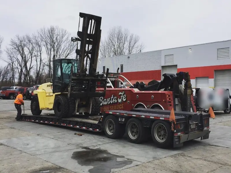 Santa Fe lowboy transporting large forklift